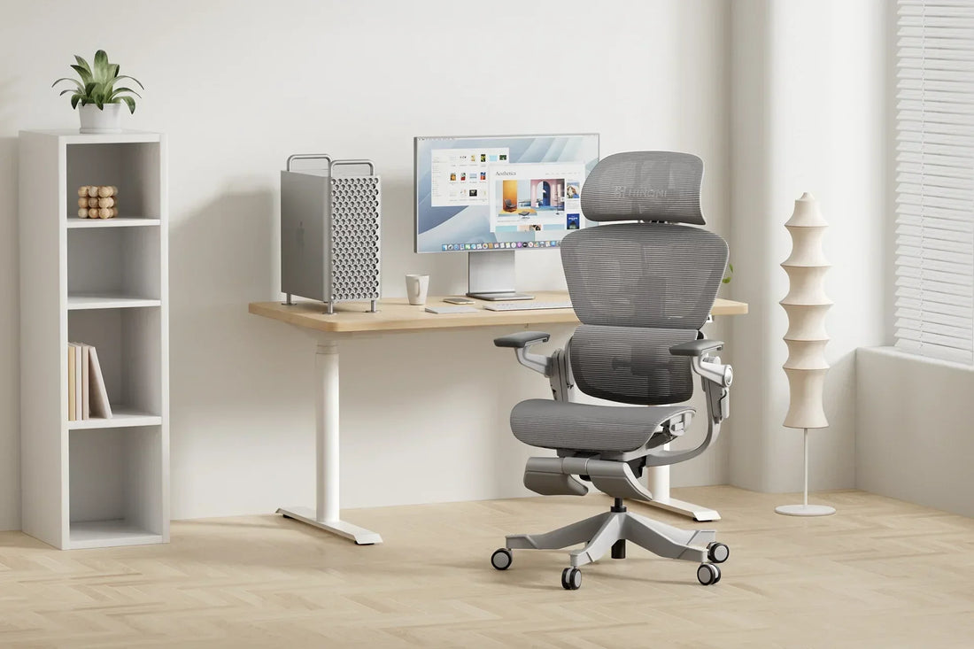 Modern home office setup featuring a Hinomi ergonomic chair, standing desk, desktop computer, and minimalist decor.