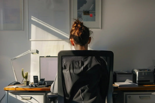 Woman working at a desk in a home office, back view.