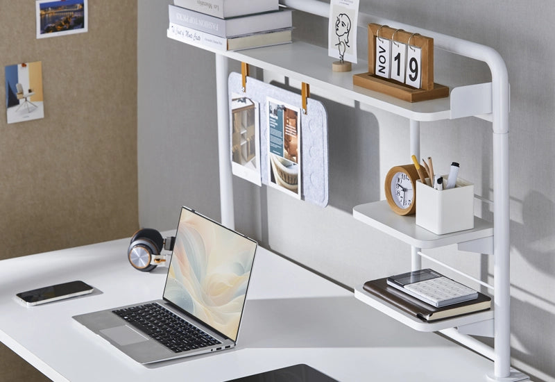 Organized white desk with shelves, accessories, and an open laptop.