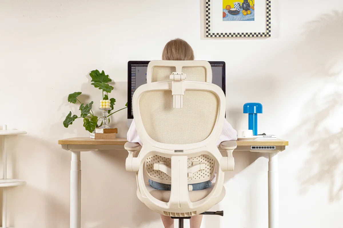 Person arbeitet am Schreibtisch in einem Hinomi-Stuhl
